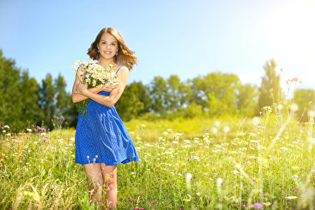 Beautiful girl with bunch of camomiles. countryside