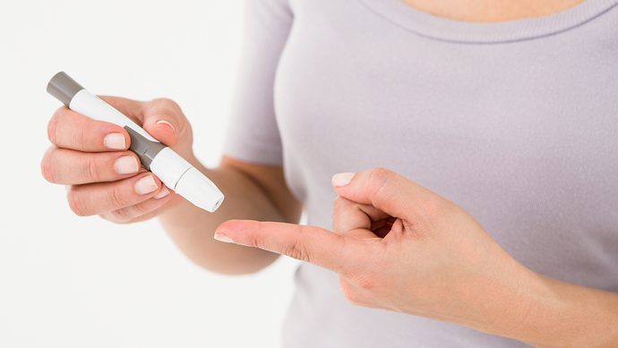 Diabetic woman using blood glucose monitor on white background