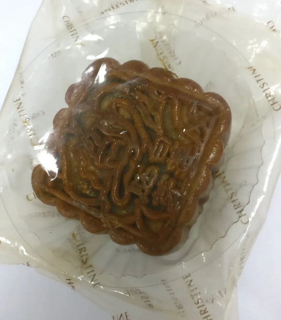 这个陈年月饼是个方形的“胚芽白莲”月饼。从背面看，小包装内还有一个标注“不可食用”的脱酸素剂。