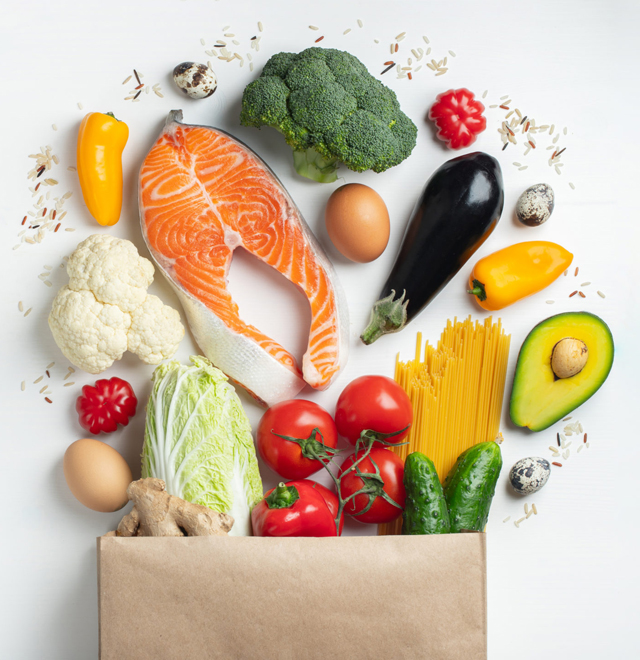 Supermarket. Paper bag full of healthy food on a white background. Top view. Flat lay. Copy space.