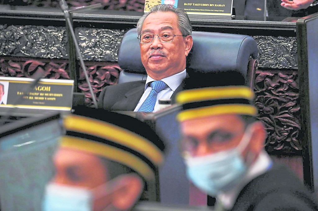 FILE PHOTO: Malaysia's Prime Minister Muhyiddin Yassin reacts during a session of the lower house of parliament, in Kuala Lumpur