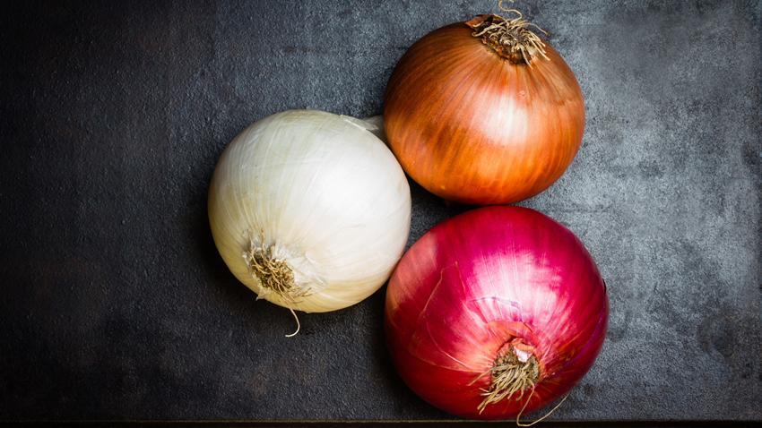 Different colorful onion on black background. Top view