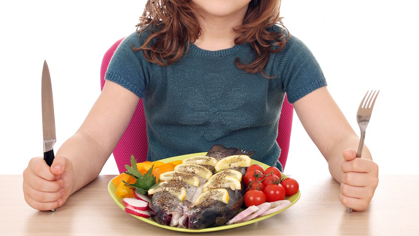 hungry little girl with fish for lunch