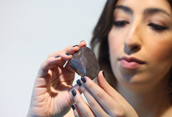 A picture taken on January 17, 2022 shows "The Enigma", a 555.55 carat black diamond, at Sotheby's in the Gulf emirate of Dubai. (Photo by Giuseppe CACACE / AFP)