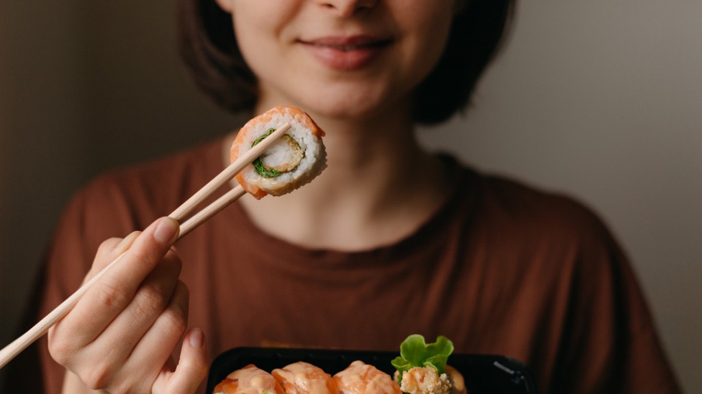 Eating,Sushi,With,Chopsticks,Close,Up,,Food,Takeout,And,Delivery