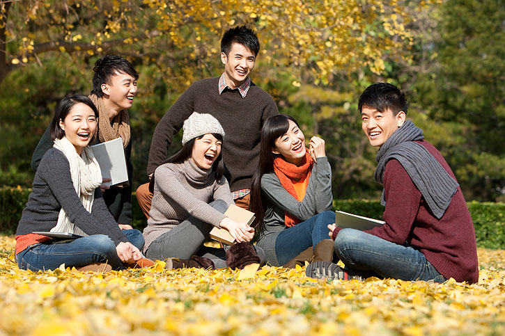 Excited Chinese college students on campus in a beautiful autumn day