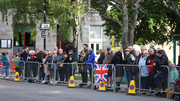 People line the street waiting for the funeral cortege carrying Britain's Queen Elizabeth in the village of Ballater, following the Queen's passing, near Balmoral, Scotland, Britain, September 11, 2022. REUTERS/Hannah McKay