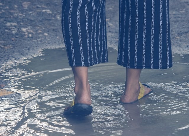 Woman,Is,Walking,On,Wet,Dirty,Road,After,Raining.