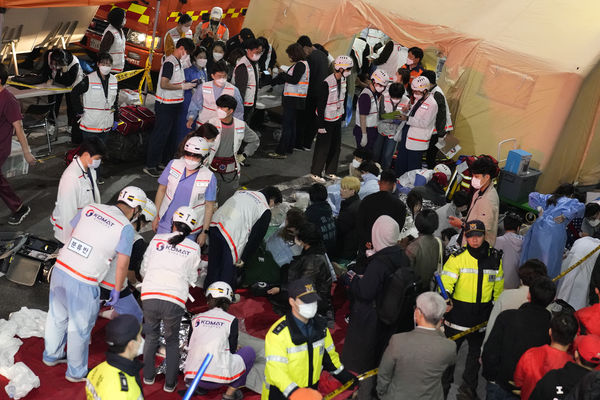 Rescue workers treat injured people on the street near the scene in Seoul, South Korea, Sunday, Oct. 30, 2022. South Korean officials say at least 120 people were killed and 100 more were injured as they were crushed by a large crowd pushing forward on a narrow street during Halloween festivities in the capital of Seoul. Choi Seong-beom, chief of Seoul’s Yongsan fire department, said the death toll could rise, saying that an unspecified number among the injured were in critical conditions. (AP Photo/Lee Jin-man)