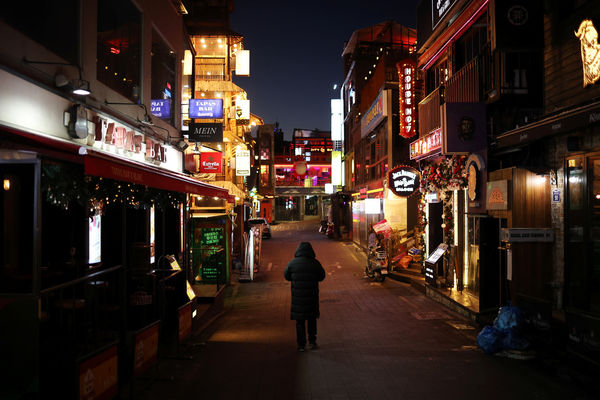 A man walks on an empty street of Itaewon near where the deadly Halloween crush that killed more than 150 in October happened, in Seoul, South Korea, December 18, 2022.  REUTERS/Kim Hong-Ji