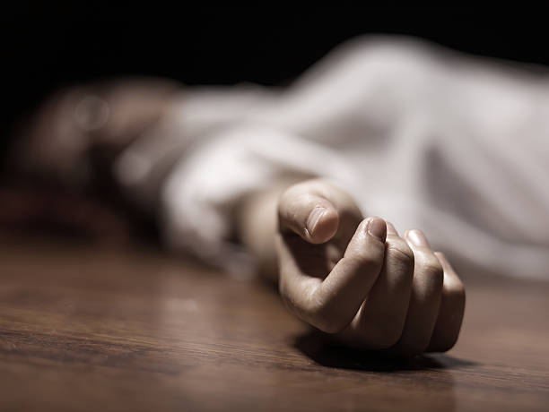 The dead woman's body. Focus on hand