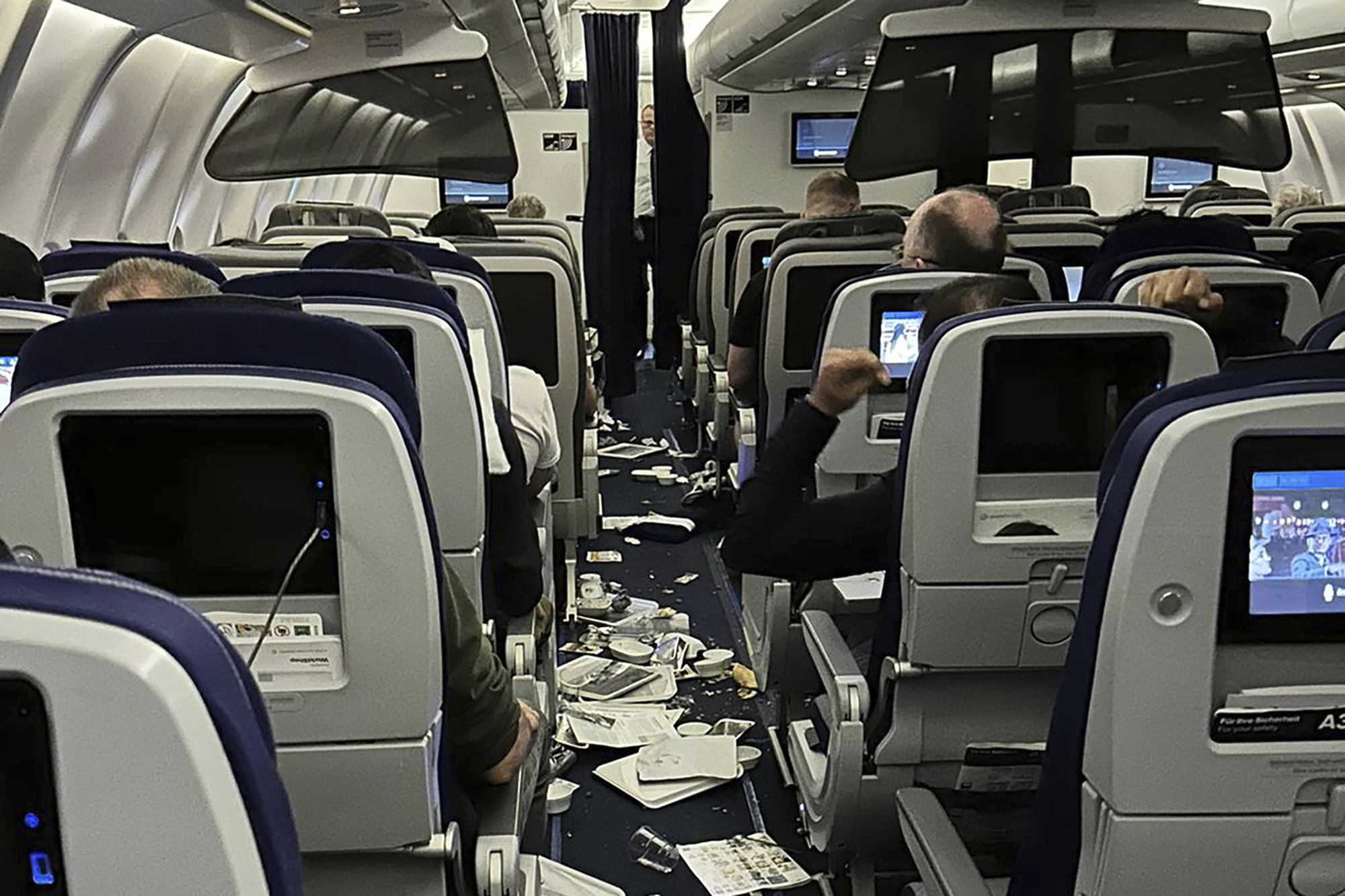 Food trays and other stuff are scattered inside the cabin as Lufthansa Flight 469 from Austin, Texas, headed to Frankfurt, Germany, that experienced “significant turbulence” and was diverted to Washington Dulles International Airport, Virginia, where it landed safely Wednesday, March 1, 2023. Crews responded to the flight and took seven people to hospitals with injuries that were believed to be minor. (Ecaterina Fadhel/via AP Photo)