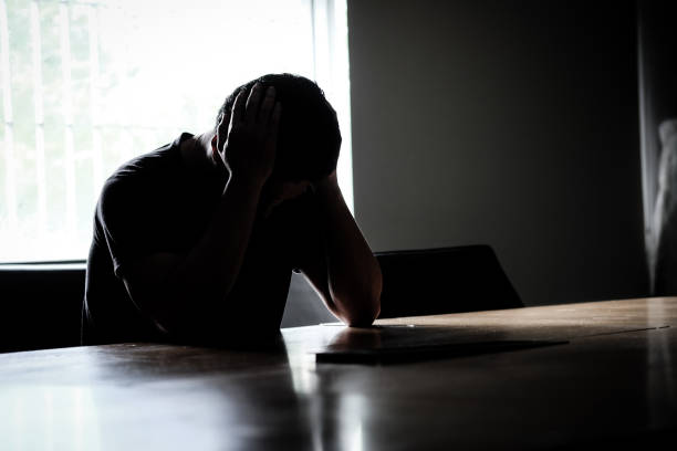 Asian men have stress Headache at the conference table in the dark in the meeting room