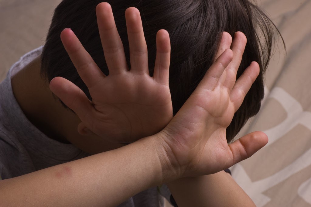 Child raising hands to protect itself