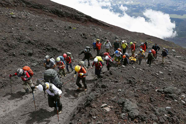 拉着三浦雄一郎上山的登顶团队，需要有１人在最前方探路，８人拉绳子，３人在轮椅旁保持平衡，才能把他拉上富士山。