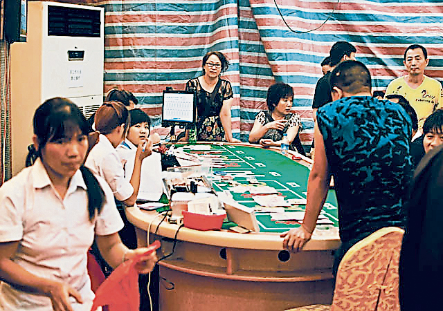 塑料布搭起来的赌棚，一样是围满赌客。