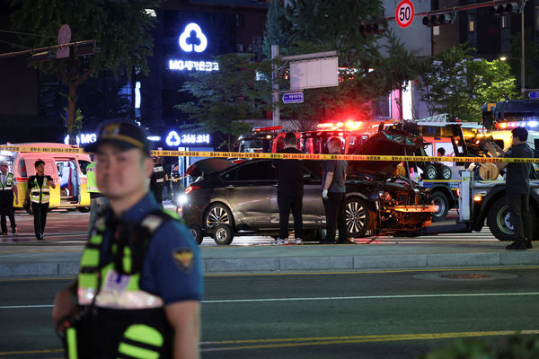 Police and rescuers stand next to a car involved in accident that resulted in several people killed and injured in central Seoul, South Korea July 1, 2024. REUTERS/Kim Hong-Ji