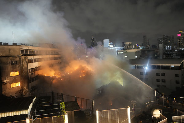 Thai fire fighters attempt to control fire at Chinatown in Bangkok, Thailand, Sunday, July 7, 2024. The nighttime blaze began in a row of shophouses behind a hotel, but was difficult to put out because they were accessible only by a narrow alley. No deaths were reported. (AP Photo/Sakchai Lalit)