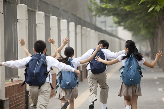 Rear view of lively Chinese schoolchildren in uniform on the way to school